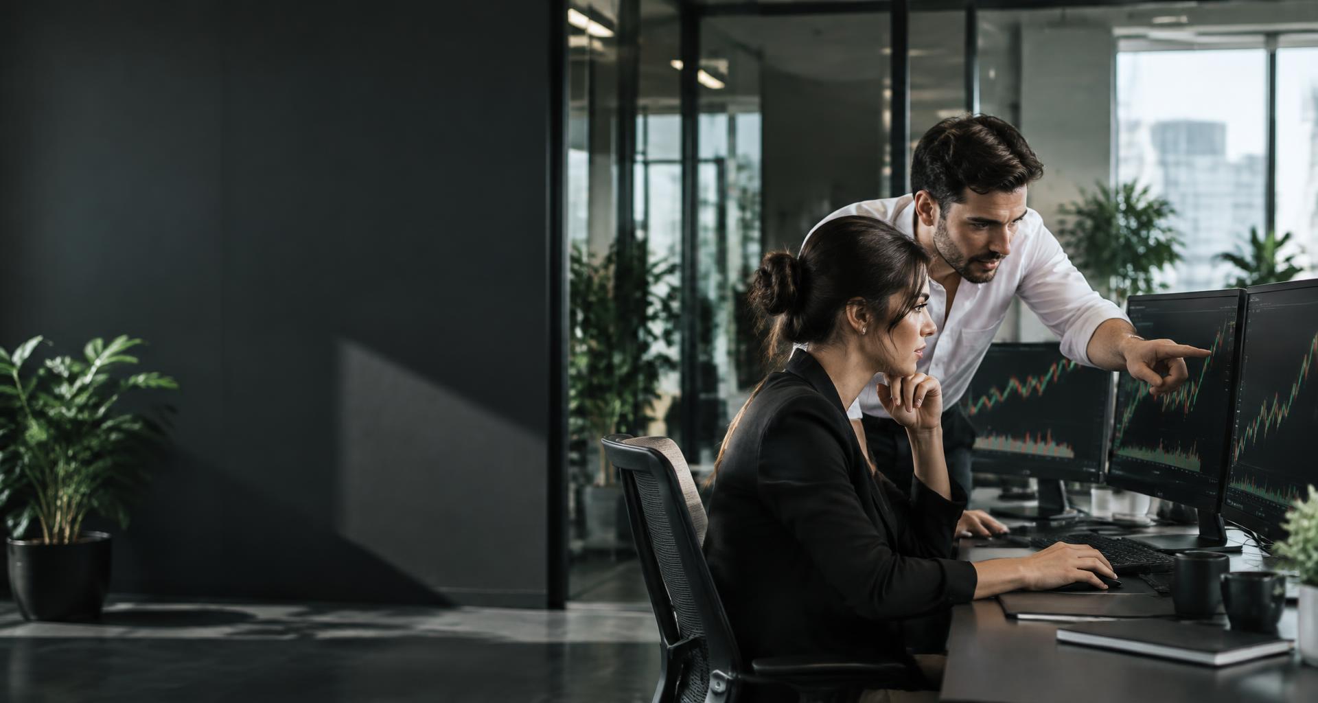 Professionals following candlestick trading charts at their computers